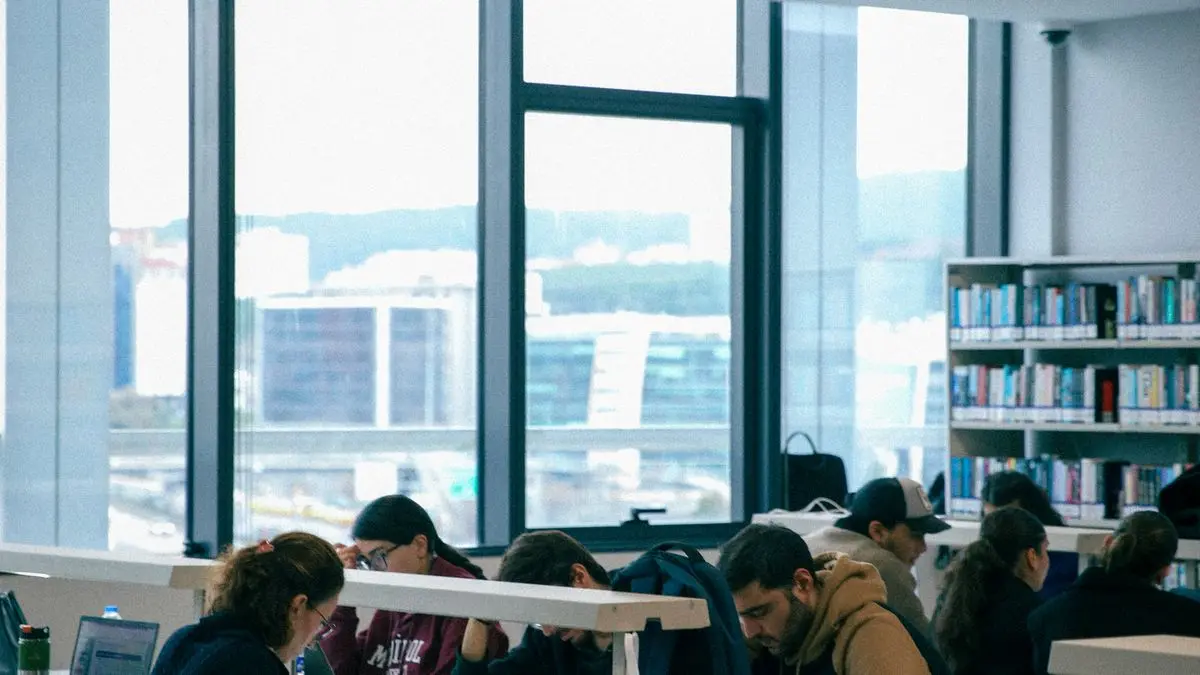 Estudiantes estudiando con sus apuntes en una biblioteca moderna de Yucatán