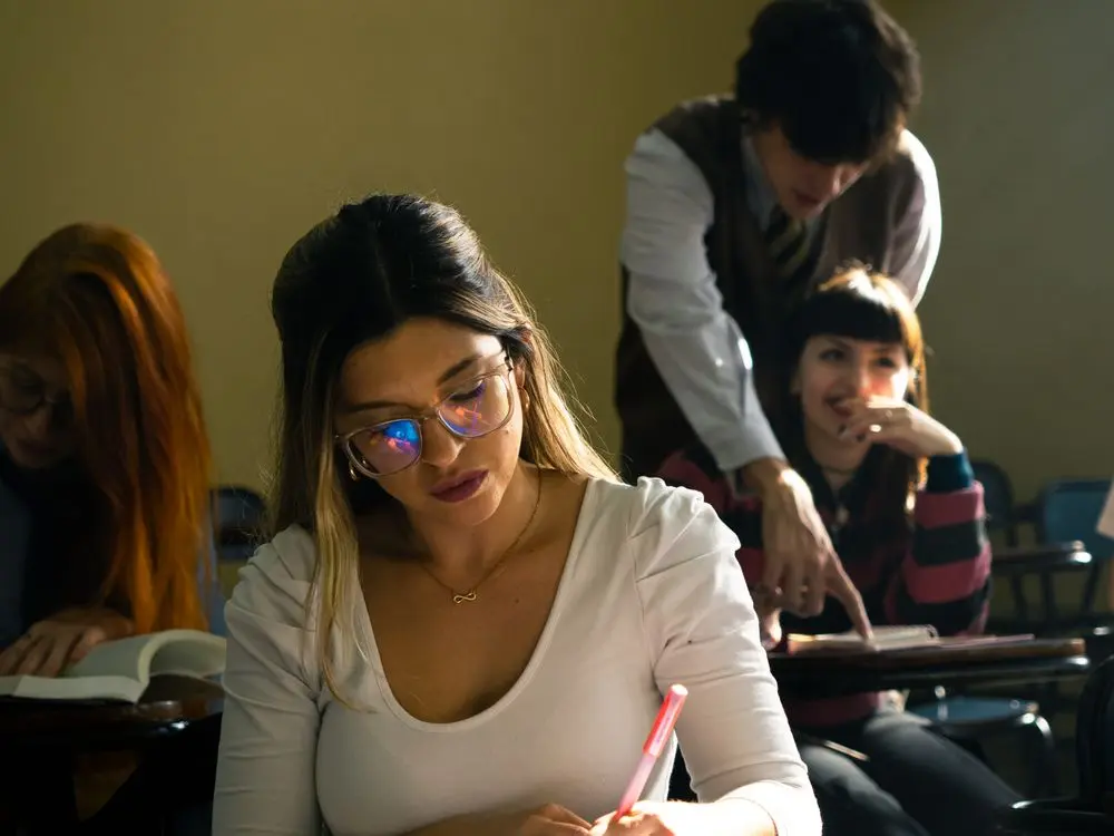 Estudiantes participando en una clase dentro de un aula